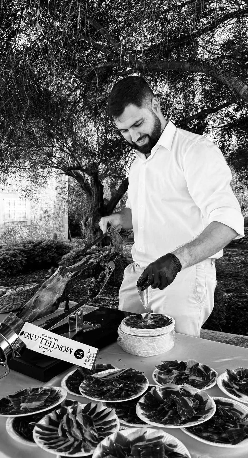 Maestro cortador de La Velada del Jamón cortando jamón ibérico a cuchillo en un evento