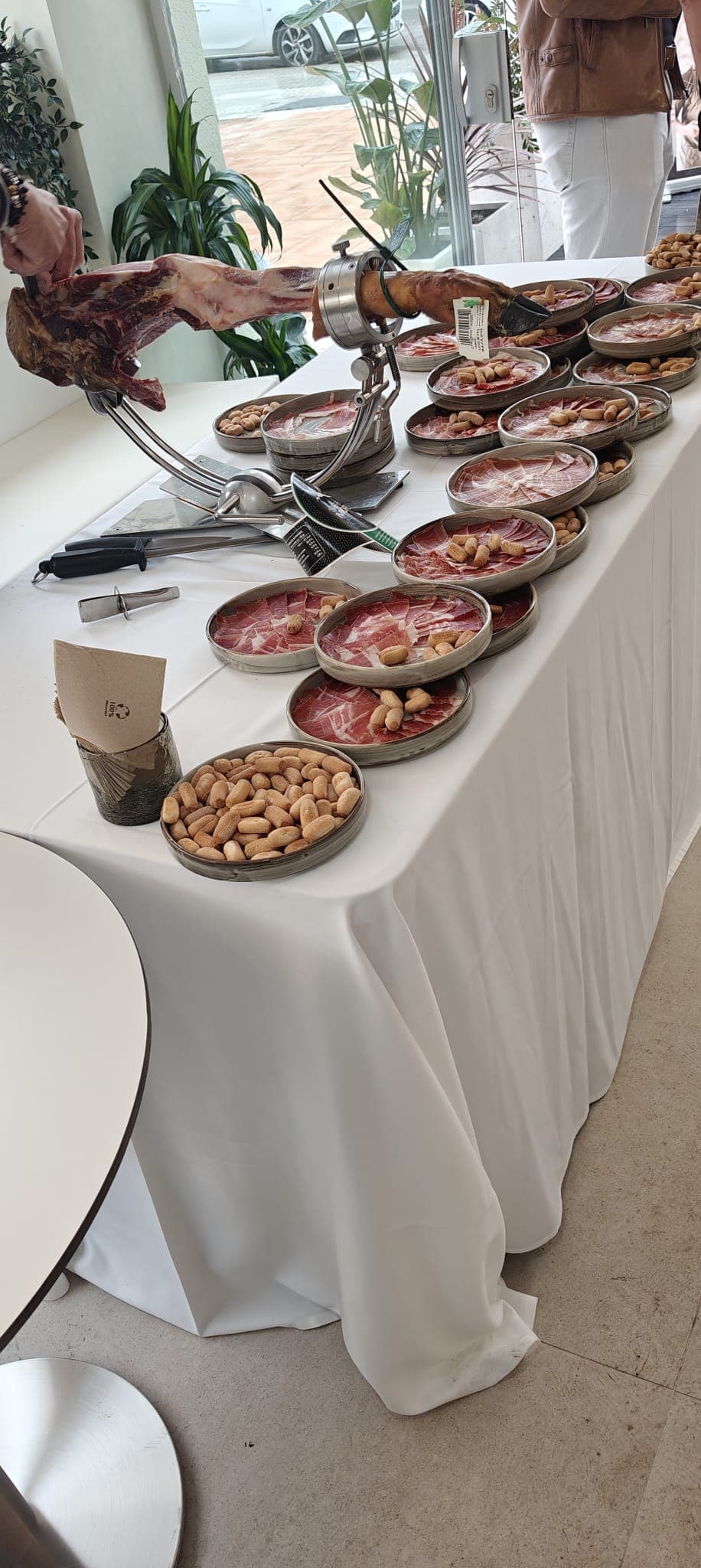 Mesa de jamón ibérico con platos servidos en un evento